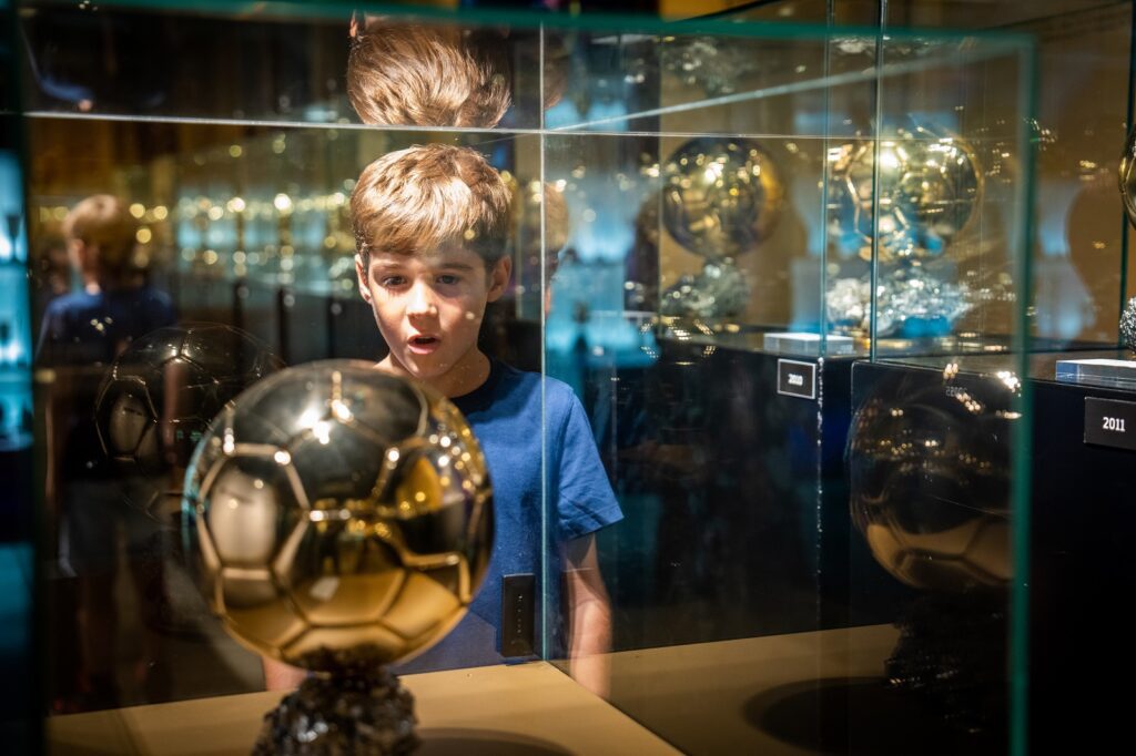 Kid looking at a trophy at the FC Barcelona Museum