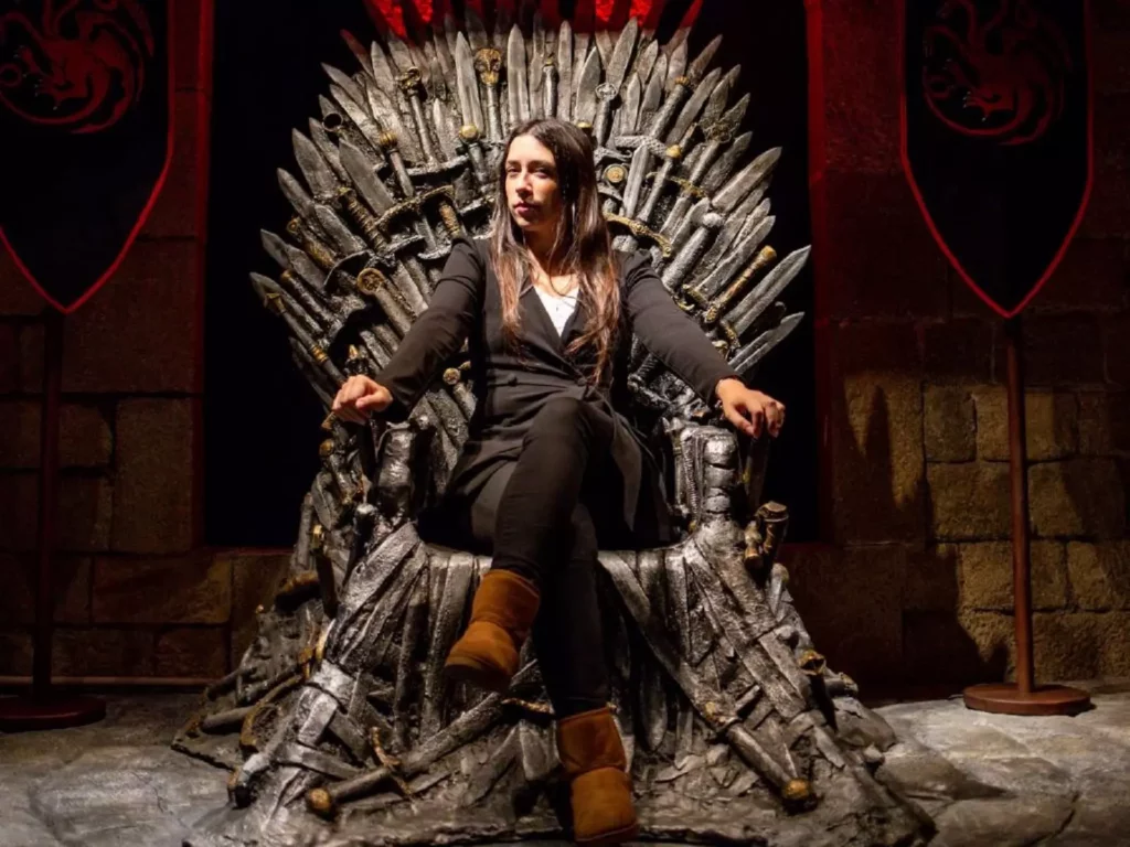 Visitante sentada sobre el trono de Game of Thrones